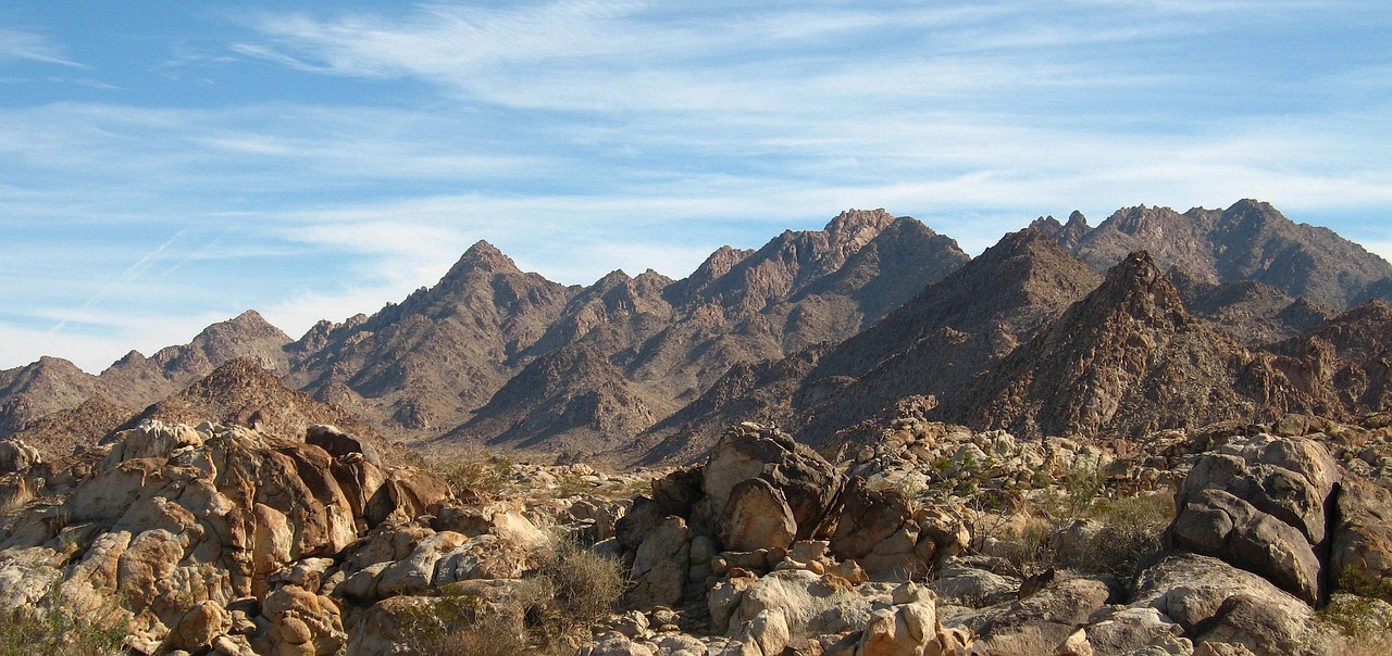 A person standing on a mountain peak looking at the sunrise, symbolizing freedom.