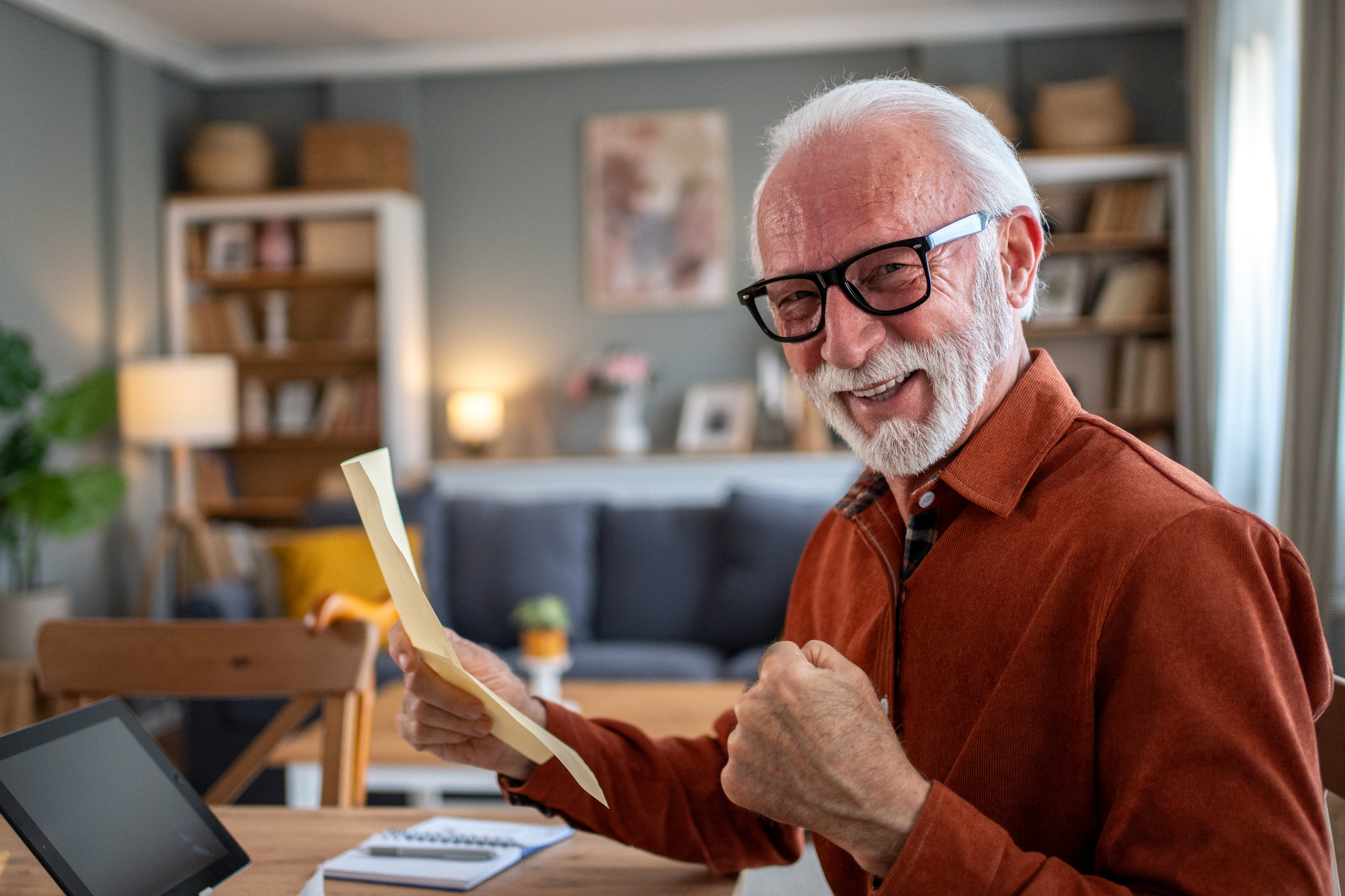 A man celebrating his financial wins while looking at his smartphone.