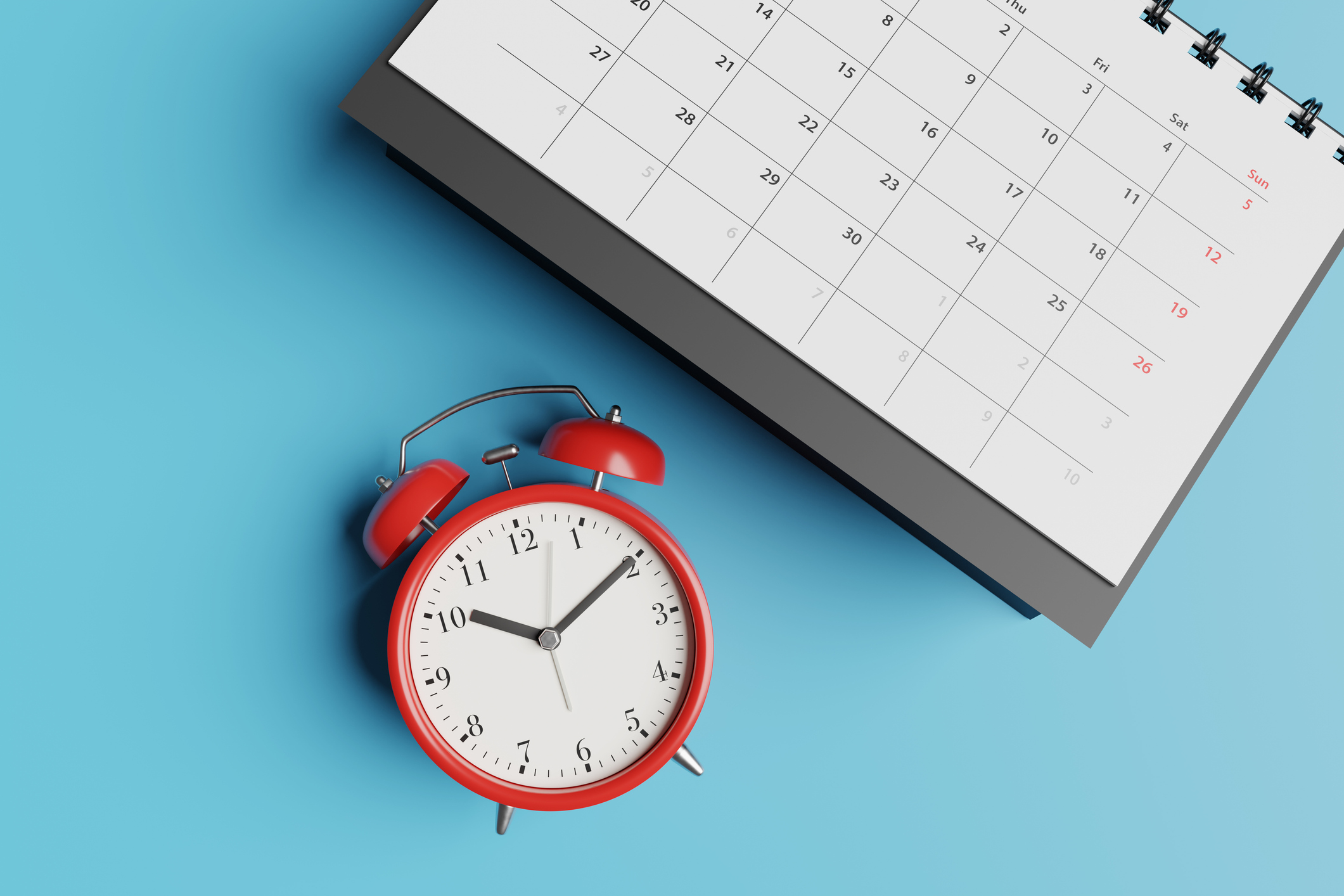 A red alarm clock and a calendar against a blue background.
