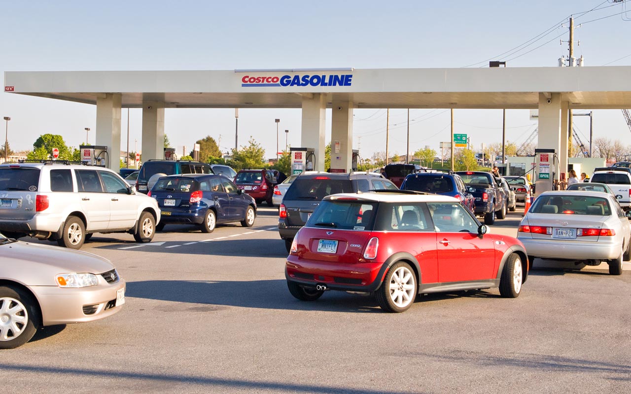 Lines of cars at a Costco gas station at midday.